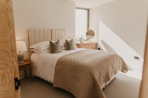 a white bedroom with a large bed with pillows at Clifftops Lodge in Portland