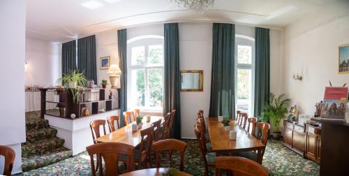 a dining room with tables and chairs and windows at Safestay Berlin Kurfurstendamm in Berlin
