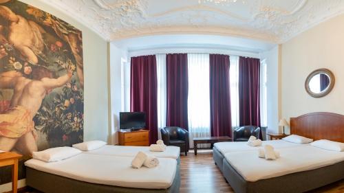 a hotel room with two beds and a painting on the wall at Safestay Berlin Kurfurstendamm in Berlin