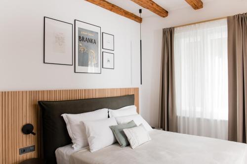 a bedroom with a bed with white pillows and a window at Boutique Hotel HOH in Zagreb