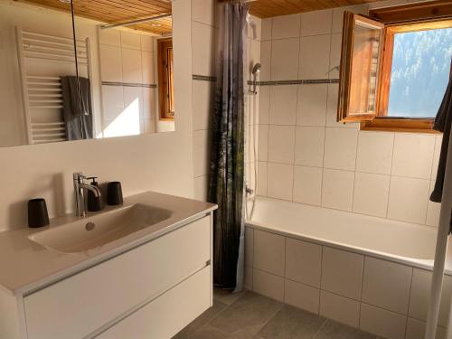 a bathroom with a sink and a bath tub at Idyllisch gelegene grosszügige Ferienwohnung Chumma in Frauenkirch