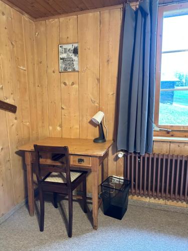 a desk with a lamp and a chair next to a window at Landhauszauber Chumma 136m2 in Frauenkirch