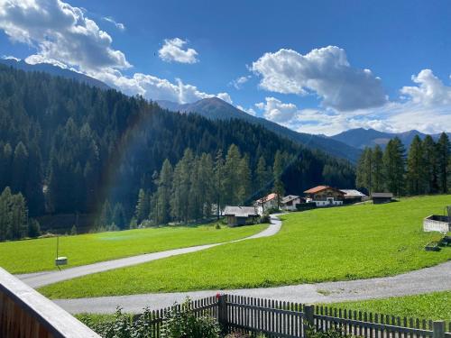 a green field with a fence and a road at Landhauszauber Chumma 136m2 in Frauenkirch