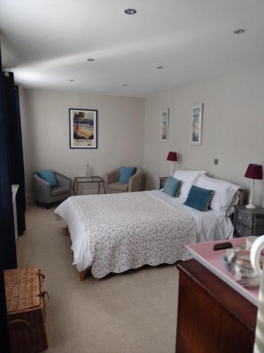 een slaapkamer met een groot wit bed en blauwe kussens bij 1 Courtyard Mews in Penzance