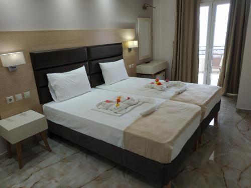 a bedroom with a large bed with two towels on it at Rachoni Deluxe Fresh in Skala Rachoniou