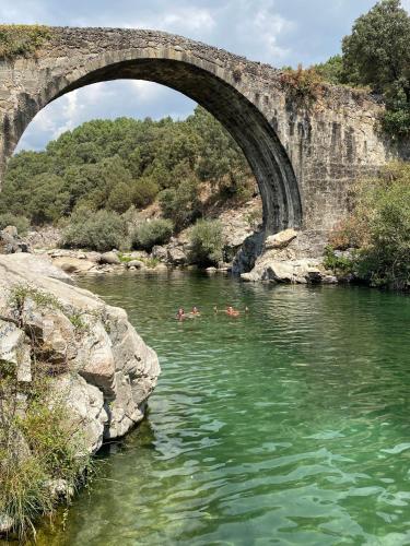 a group of people swimming in a river under a bridge at CASA PARVATHI CANDELEDA in Candeleda