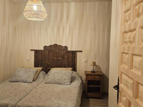 a bedroom with two beds and a chandelier at CASA PARVATHI CANDELEDA in Candeleda