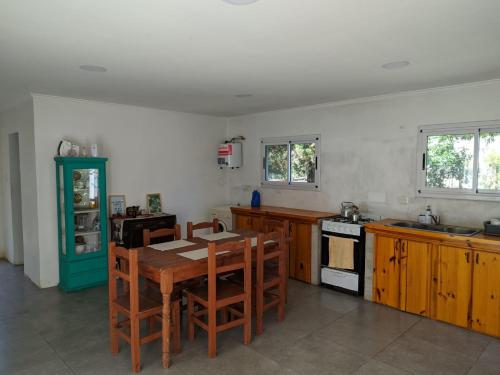 een keuken met een tafel en stoelen en een fornuis bij Casa Lidia in Chascomús