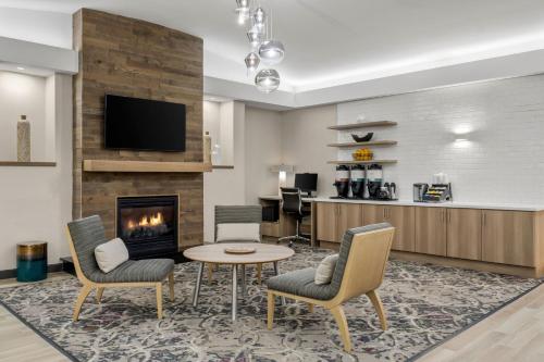 a living room with a table and chairs and a fireplace at Residence Inn by Marriott Chicago Naperville/Warrenville in Warrenville