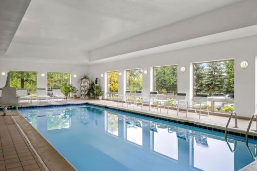 a swimming pool in a hotel with chairs and tables at Residence Inn by Marriott Chicago Naperville/Warrenville in Warrenville