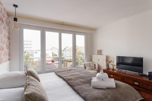 une chambre avec un lit et une grande fenêtre dans l'établissement Starfish - Charmant appt à 3min à pied de la plage, à Saint-Malo