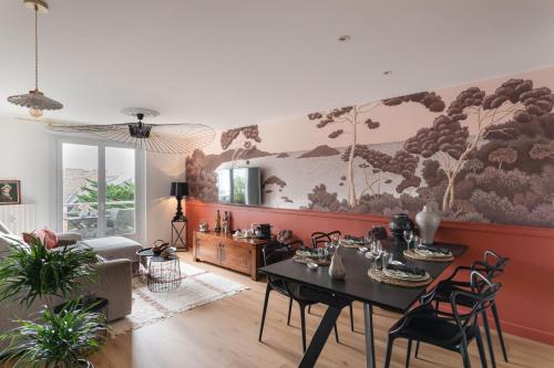 - un salon avec une table et des chaises ainsi qu'une peinture murale dans l'établissement Starfish - Charmant appt à 3min à pied de la plage, à Saint-Malo