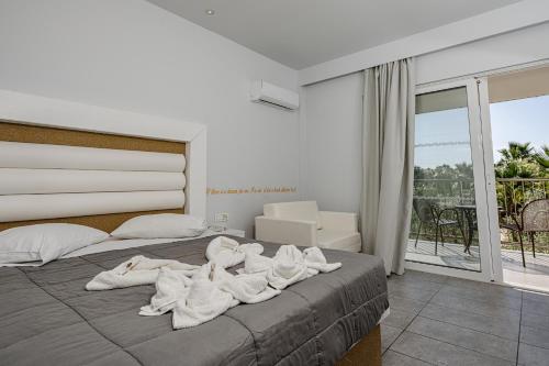 um quarto com uma cama grande e toalhas em Caretta Island em Kalamaki