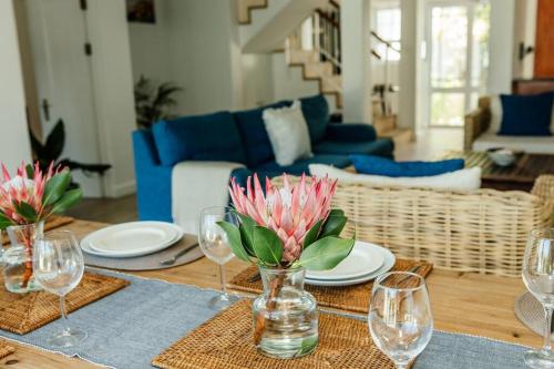 - une table avec des verres à vin et des fleurs dans le salon dans l'établissement Avisa Villa - 4 bedroom Villa with Majestic Ocean Views, au Cap