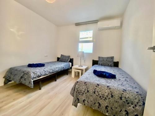 a bedroom with two beds with blue pillows on them at Los Marinos 36 in Puerto del Carmen