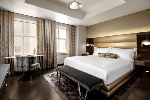 a bedroom with a bed and a desk and a window at The Sinclair, Autograph Collection in Fort Worth