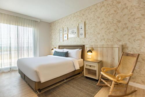 1 dormitorio con 1 cama, 1 silla y 1 ventana en Ermita Cartagena, a Tribute Portfolio Hotel, en Cartagena de Indias