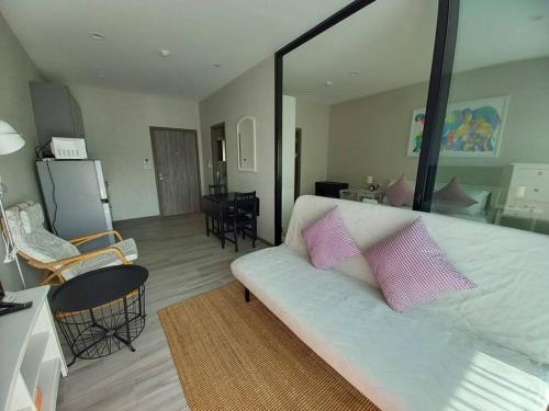 sala de estar con sofá blanco y almohadas rosas en B6 НОВАЯ на БАССЕЙН ВАТСАП669З582I976, en Nai Yang Beach