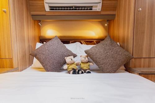 two teddy bears sitting on a bed with pillows at Sterling seastar ที่พักติดชายหาด วิวทะเล 