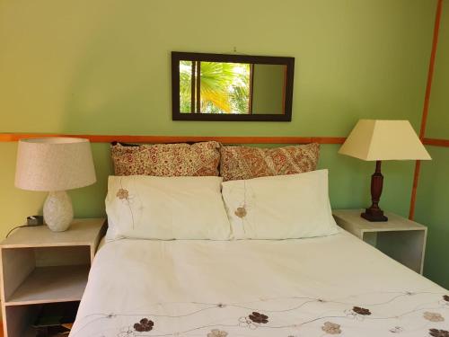 a bedroom with a bed with two lamps and a mirror at The Farmhouse Palm Tree Cabin in Stellenbosch