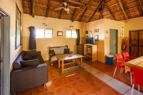 - un salon avec un canapé et une table dans l'établissement African Sunsets (Bophirimo Self-Catering Guest House), à Kasane