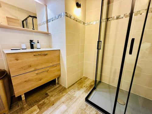La salle de bains est pourvue d'une douche et d'une commode en bois. dans l'établissement Le Pré - Port Fréjus, bord de Mer et Base Nature, à Fréjus