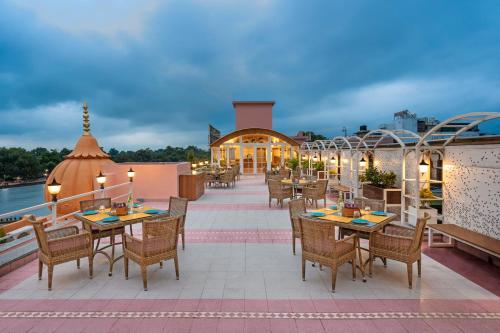 un restaurante con mesas y sillas en un balcón en Ganga Lahari by Leisure Hotels, en Haridwar