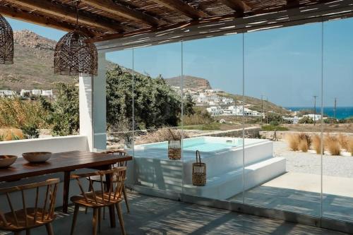 ein Esszimmer mit einem Tisch und Meerblick in der Unterkunft Luxury Cycladic Villa with Seaview and MiniPool in Naxos Chora