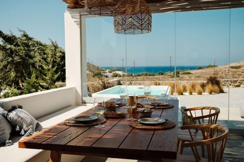 einen Holztisch auf einer Terrasse mit Meerblick in der Unterkunft Luxury Cycladic Villa with Seaview and MiniPool in Naxos Chora