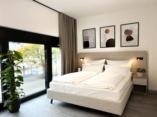 a bedroom with a white bed and a large window at ARUS Hotels in Hamburg