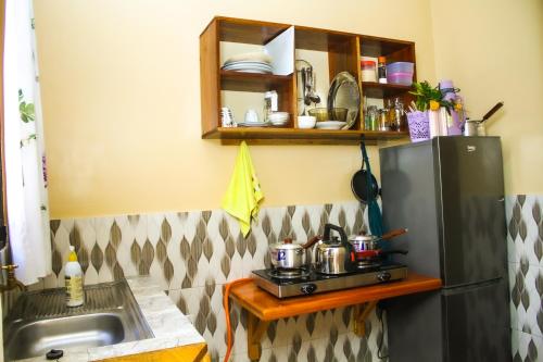 a kitchen with a sink and a refrigerator at Margareth's Home Stay Free Wi-Fi and Tv in Tanga