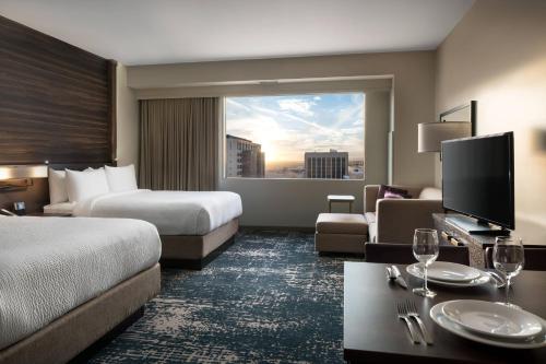 Habitación de hotel con 2 camas y ventana grande. en Residence Inn by Marriott Phoenix Downtown, en Phoenix