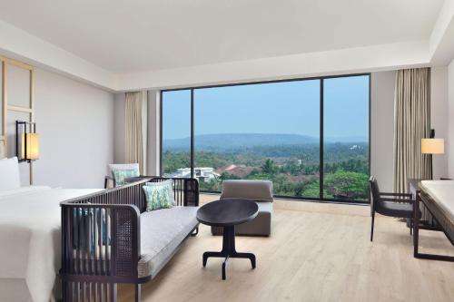 a hotel room with a bed and a couch and a desk at The Westin Goa in Vagator