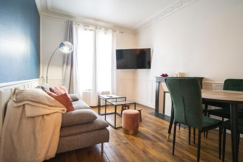 a living room with a couch and a table at Cozy love cocoon in Boulogne-Billancourt's heart in Boulogne-Billancourt