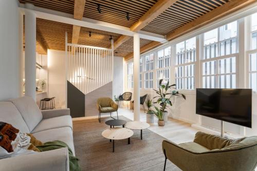a living room with a couch and a tv at NORO Plaza in A Coruña