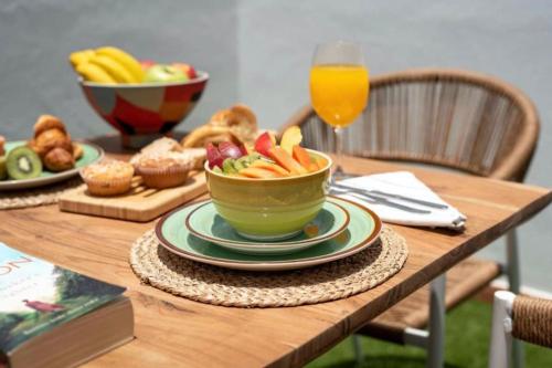 einen Holztisch mit einer Schüssel Essen und einer Schale Obst in der Unterkunft Apartamento Jaira in Playa Honda