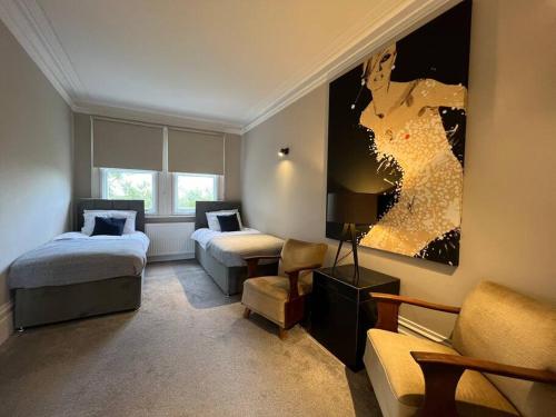 una camera d'albergo con due letti e un divano di Star London Warwick Mansions 3-Bed Haven a Londra