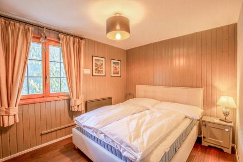 a bedroom with a large bed and a window at Chalet La Neuf in Blitzingen