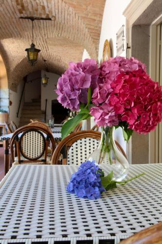 a vase filled with purple and blue flowers on a table at Hotel San Filis in San Felice del Benaco