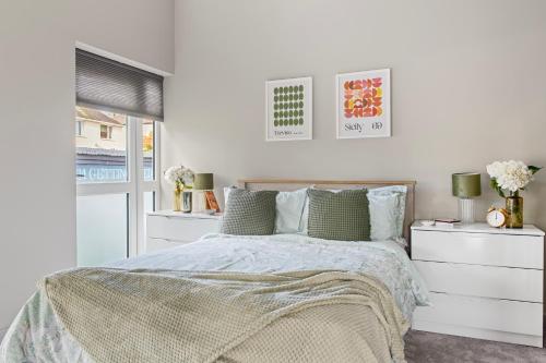 a white bedroom with a bed and two dressers at Brand New 1-Bed Flat With Free Parking in Nottingham