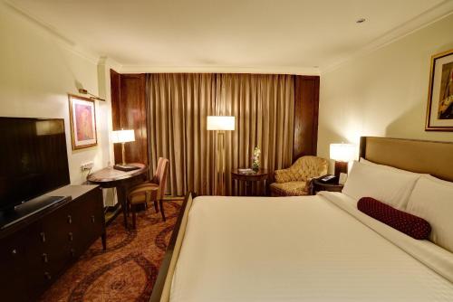 a hotel room with a bed and a desk at Pearl Continental Hotel, Lahore in Lahore