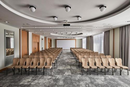a room with rows of chairs and a screen at Sheraton Poznan Hotel in Poznań