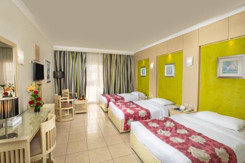 a hotel room with two beds and a desk at Naama Bay Hotel & Resort in Sharm El Sheikh