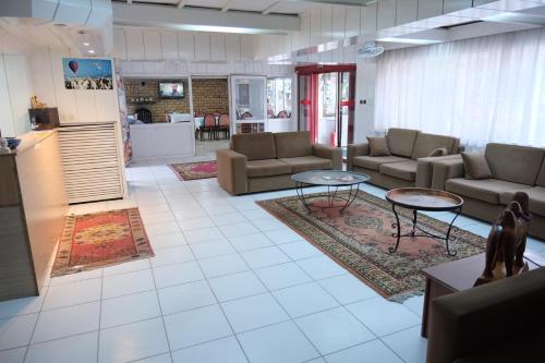 un soggiorno con divani e tavoli e una cucina di Artemis Yörük Otel Pamukkale a Pamukkale