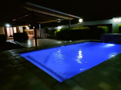 una piscina blu illuminata di notte di Soma Guesthouse a Groblersdal