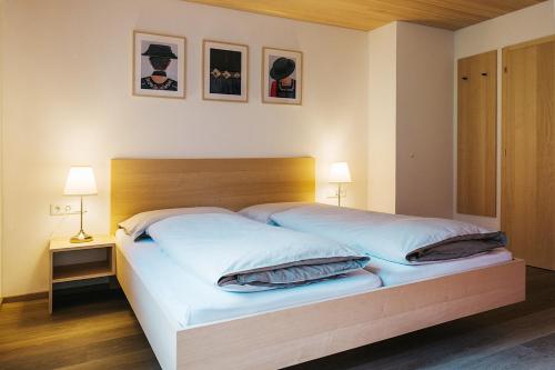 Haus Margreth في ميلاو: غرفة نوم بسرير ذو شراشف ووسائد بيضاء