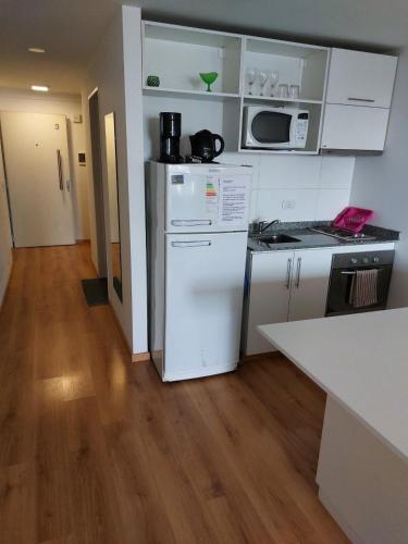 cocina con electrodomésticos blancos y suelo de madera en Excelente Departamento, piso alto en Buenos Aires