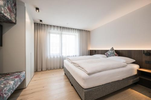 a bedroom with a large bed and a window at Luis Chalet in Brunico