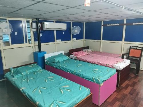 two beds in a room with blue and pink at Rajeswari Ac Dormitory For Indian males only in Port Blair