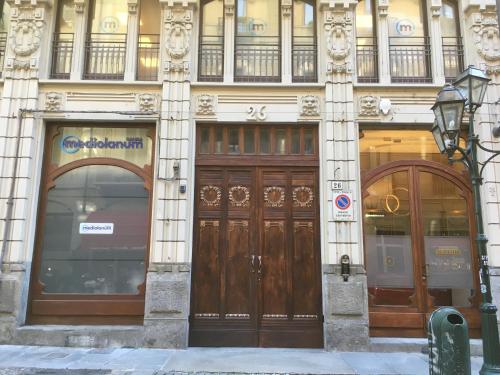 un edificio con dos grandes puertas de madera. en Suite Florio, en Turín